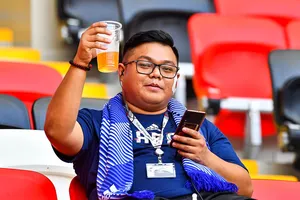 Astonishing moment fan uses head to carry obscene amount of beer