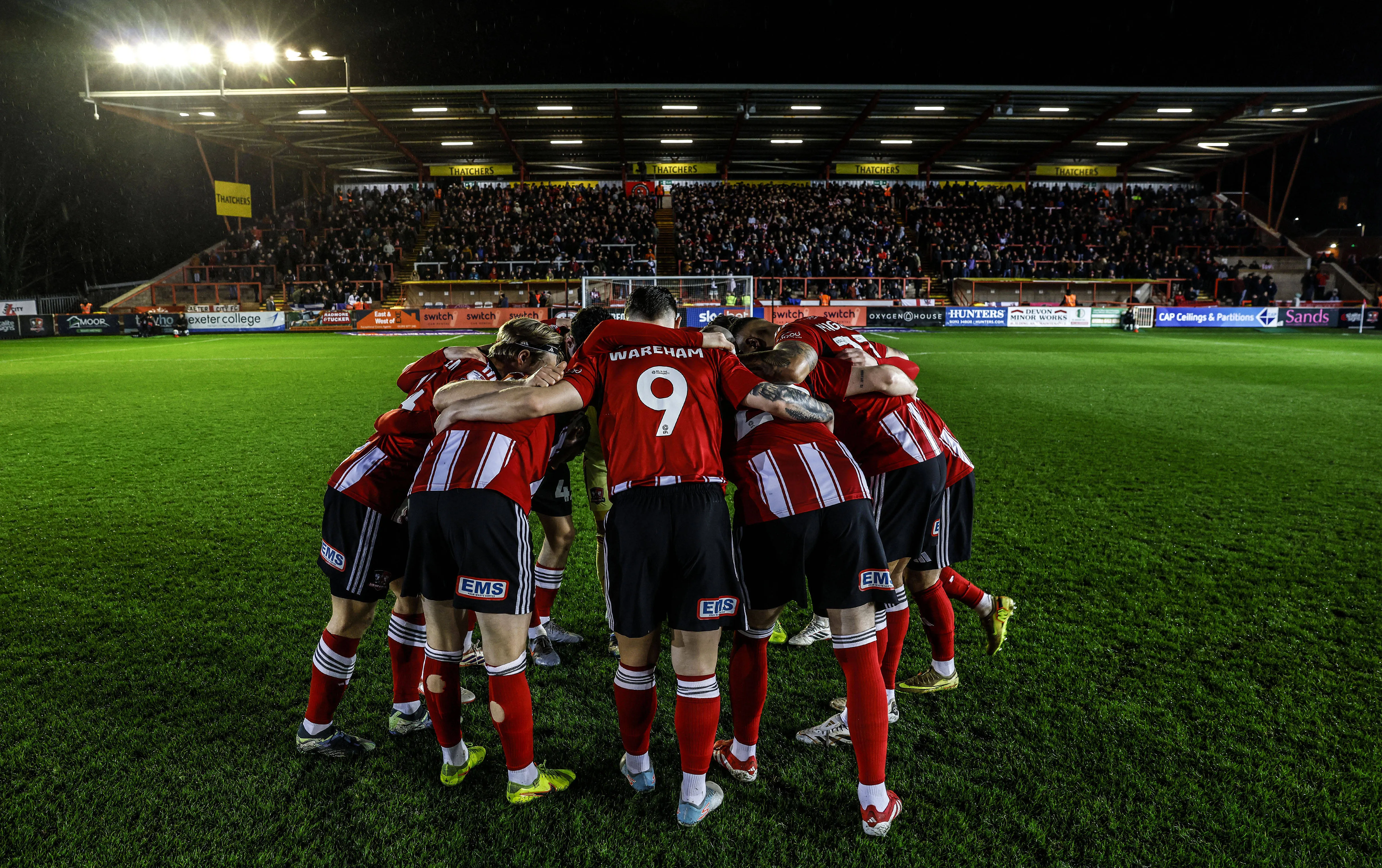 Exeter City team huddle before League One match vs Lincoln City at St James Park Stadium