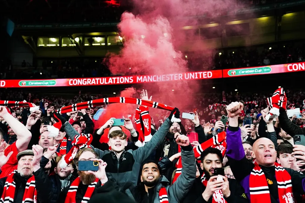 Manchester United fans in Copenhagen travel in a foul after poor results. A lot has changed since their Carabao Cup win at Wembley in February, which they celebrate in this picture.