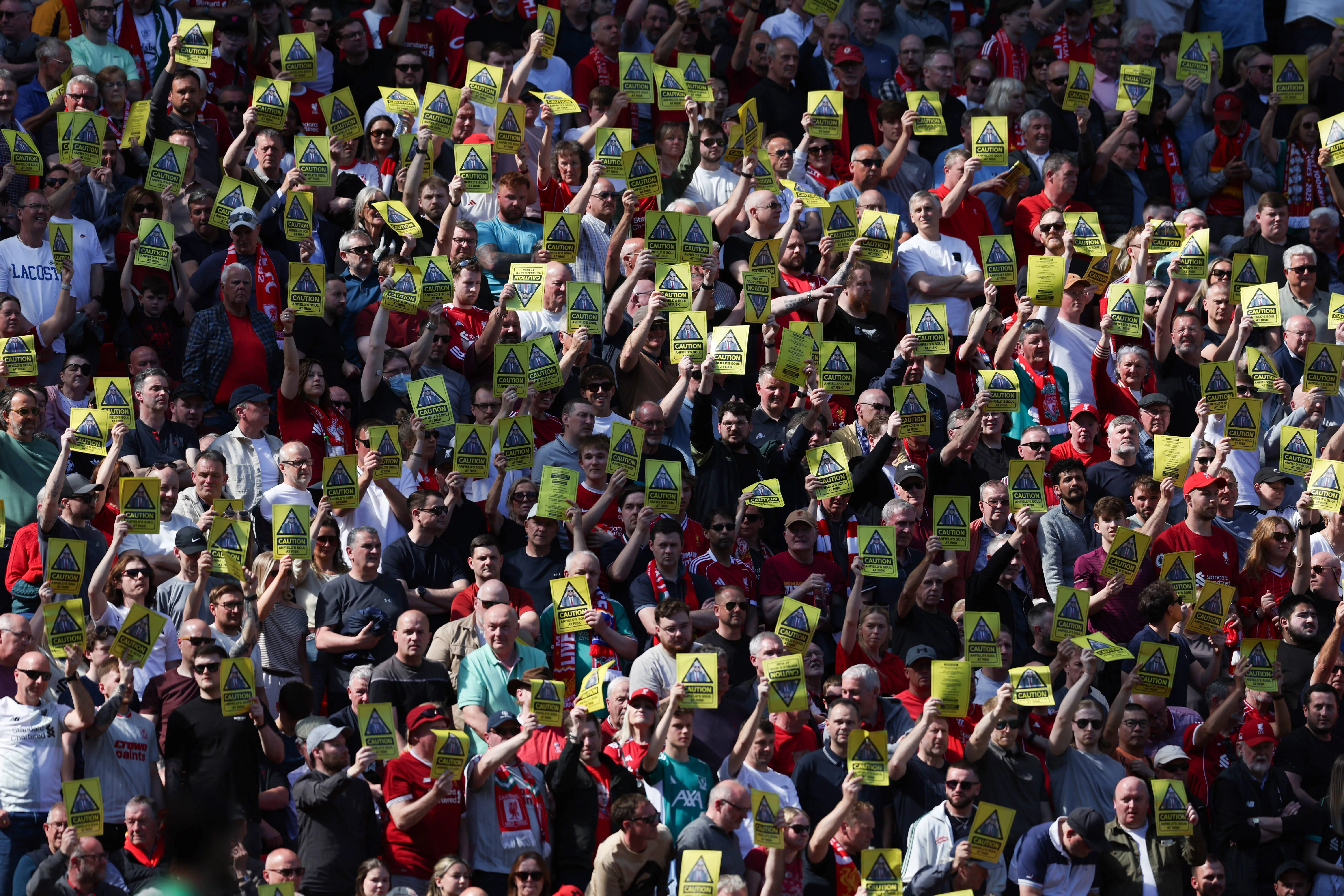 Fans of Liverpool hold up banners in protest of the decision to increase ticket prices
