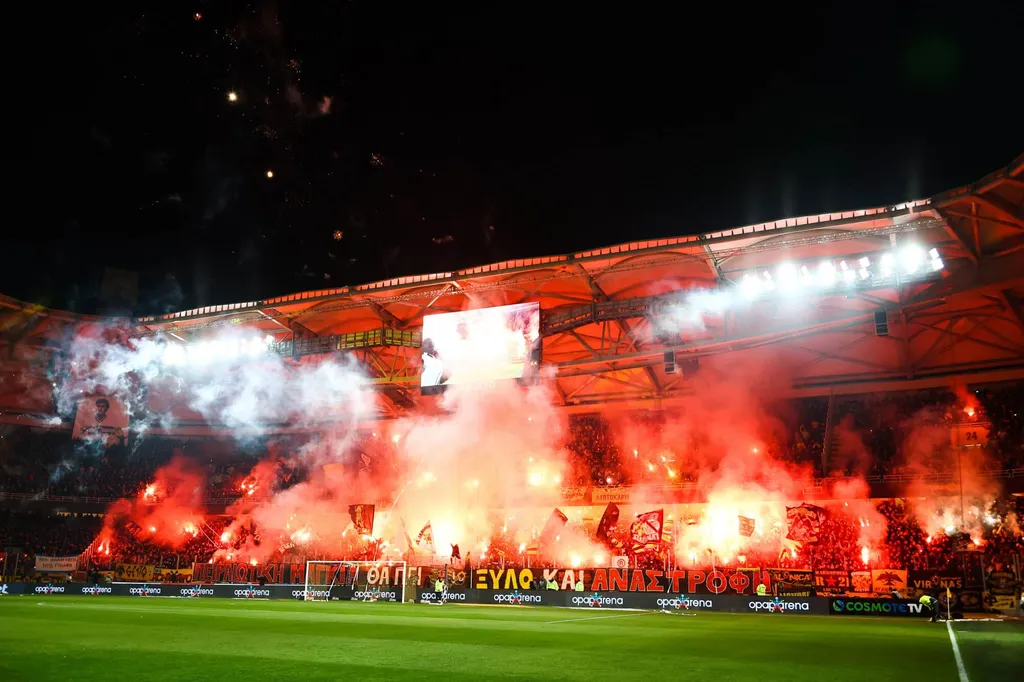 AEK Athens fans light up red flares during the Greek Cup Semi-Final First Leg match at OPAP Arena, Athens | Guide for AEK Athens away section