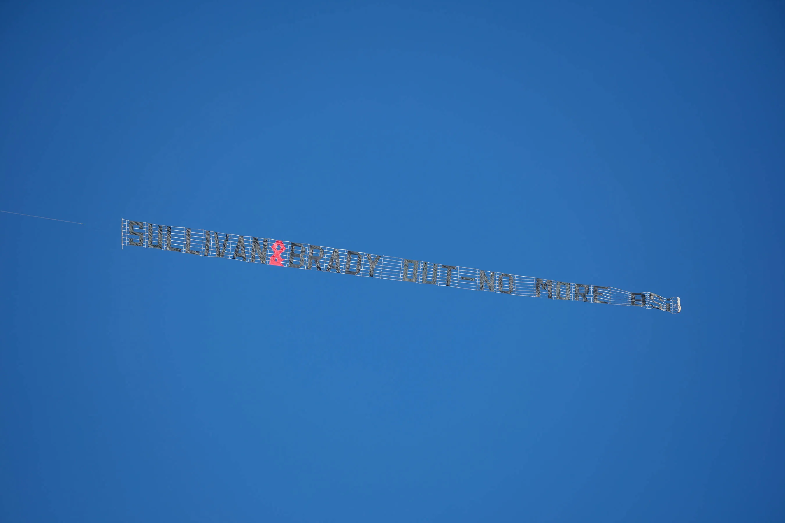 A light aircraft tows a banner calling for West Ham United owners to quit