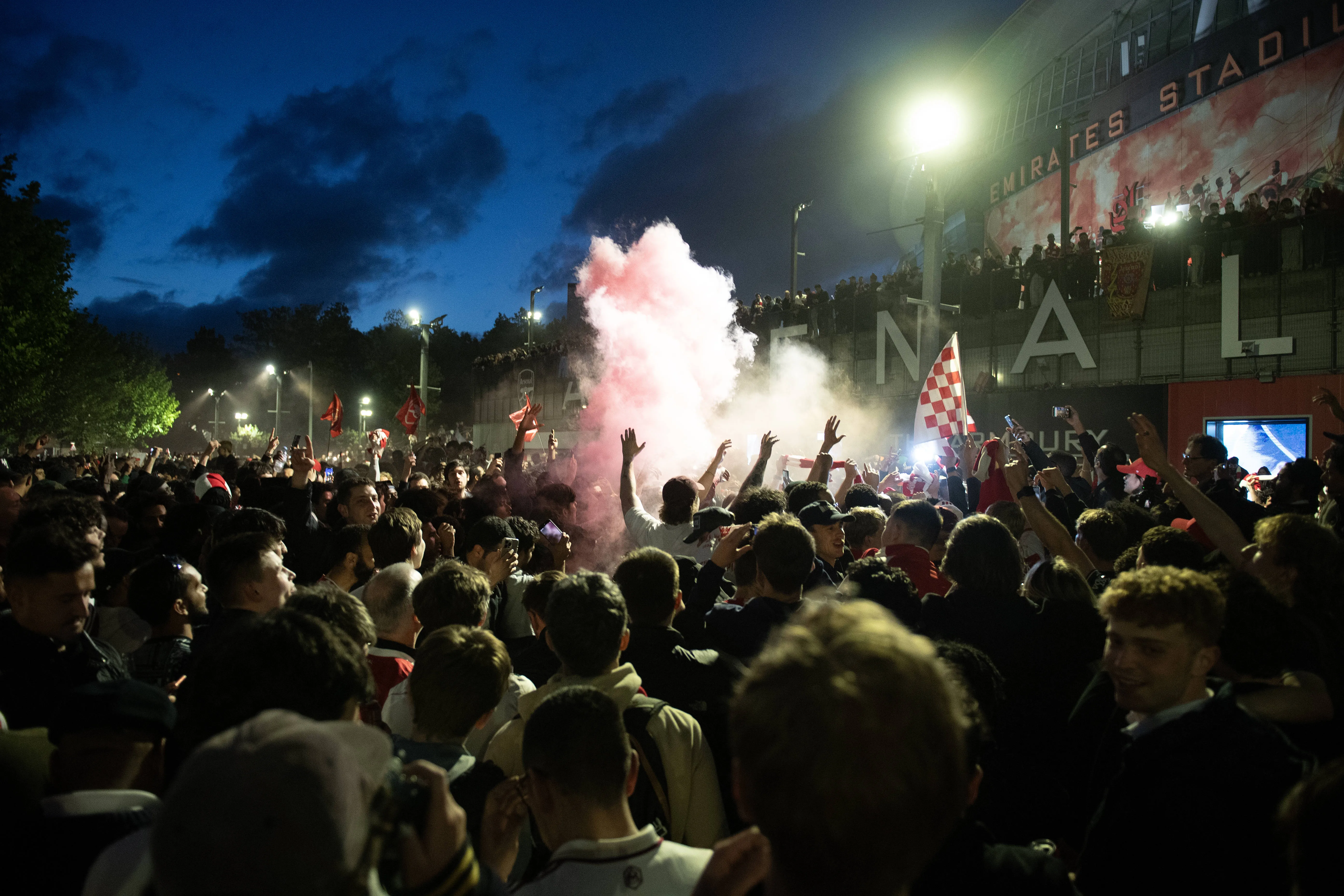 Arsenal fans celebrate winning the Premier League outside the Emirates Stadium